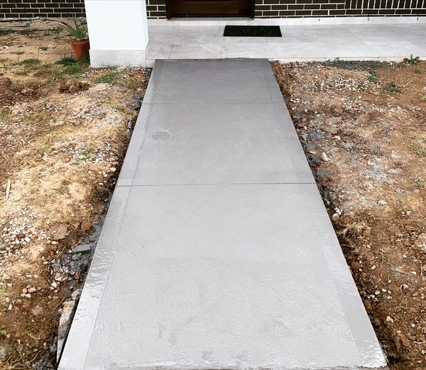 Front entry concrete path with a border finish leading to the house